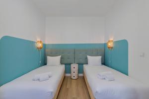 due letti in una stanza con blu e bianco di Fonz Patio House a Setúbal