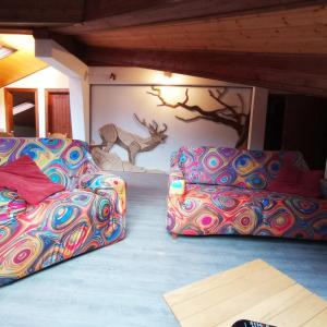 two beds in a room with a wall with a deer mural at L'angolo del buonumore in Daone