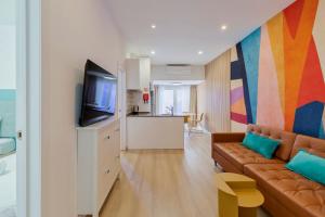 un soggiorno con un divano e una TV di Fonz Patio House a Setúbal