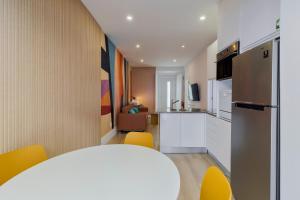 una cucina con tavolo bianco e sedie gialle di Fonz Patio House a Setúbal Altre 11 foto