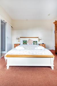 a white bedroom with a large white bed in a room at Elen's Castle Hotel in Dolwyddelan