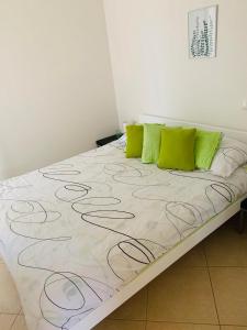 Ce lit se trouve dans un dortoir doté d'oreillers verts. dans l'établissement Josip Modern Apartment Novalja, à Novalja