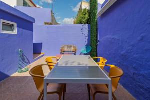 un tavolo con sedie in una stanza con pareti viola di Fonz Patio House a Setúbal