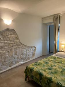 a bedroom with a bed and a stone wall at Scalette Via Elia in Numana