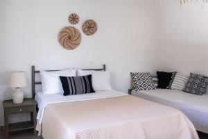 two beds sitting next to each other in a bedroom at Aloni Ios in Mylopotas