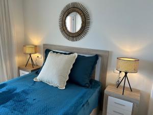 1 dormitorio con 1 cama con espejo y 2 lámparas en Playa de Oro 14C, en Calpe 21 fotos más