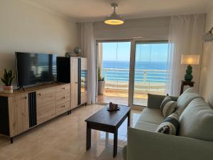 Una sala de estar con un sofá y un televisor de pantalla plana. en Playa de Oro 14C, en Calpe