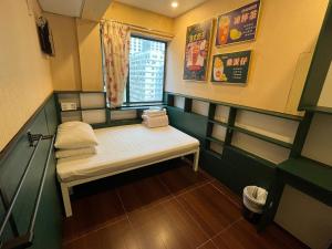 Habitación pequeña con cama y ventana en Venetian Hostel, en Hong Kong