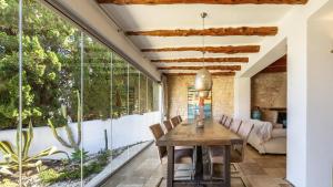 ein Esszimmer mit einem Tisch und einem großen Fenster in der Unterkunft Villa Lunablanca in Santa Eulària des Riu