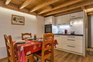 une cuisine avec une table et un chiffon rouge dans l'établissement Résidence Grand Roc - Campanules 122 - Happy Rentals, à Chamonix-Mont-Blanc