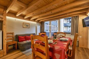 ein Esszimmer mit einem Tisch und einem Sofa in der Unterkunft Résidence Grand Roc - Campanules 122 - Happy Rentals in Chamonix-Mont-Blanc