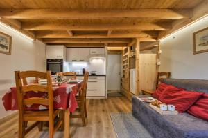eine Küche und ein Wohnzimmer mit einem Tisch und einem Sofa in der Unterkunft Résidence Grand Roc - Campanules 122 - Happy Rentals in Chamonix-Mont-Blanc