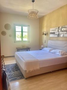 a bedroom with a large bed and a chandelier at LONG SUMMER in Sivota