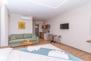 a living room with a couch and a kitchen at Sea View Suites & Holiday Homes - Plaka Beach Resort in Vasilikos