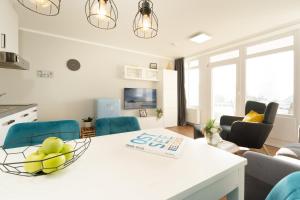 eine Küche und ein Wohnzimmer mit einem weißen Tisch und Stühlen in der Unterkunft Ferienwohnung B2 Lieblingsblick in Kellenhusen