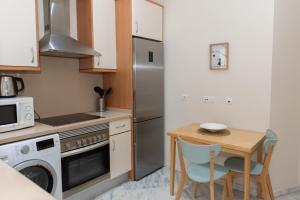 una pequeña cocina con mesa y nevera en Charming & quiet apartment in Plaza del Salvador, en Sevilla