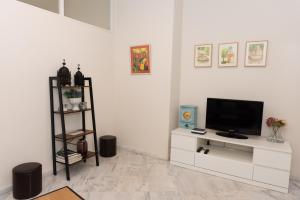 una sala de estar con TV en un armario blanco en Charming & quiet apartment in Plaza del Salvador, en Sevilla