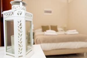 una linterna blanca sentada en una mesa en una habitación con 2 camas en Charming & quiet apartment in Plaza del Salvador, en Sevilla