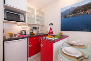 uma pequena cozinha com armários vermelhos e uma mesa em Chamonix Sud - Grepon Paradis 611 - Happy Rentals em Chamonix-Mont-Blanc
