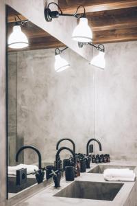 ein Badezimmer mit zwei Waschbecken und zwei Leuchten in der Unterkunft L´Ovella Negra Mountain Lodge in Canillo