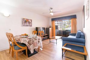 salon ze stołem i niebieską kanapą w obiekcie Oceanfront 2 bedrooms Holiday Home in Tenerife South w San Miguel de Abona