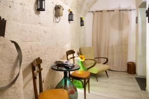 Zimmer mit Stühlen und einem Tisch mit Blumen in der Unterkunft Antico Lamione in Matera