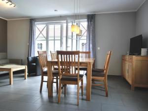 a dining room with a wooden table and chairs at Ferienhaus FH T 1d in Graal-Müritz