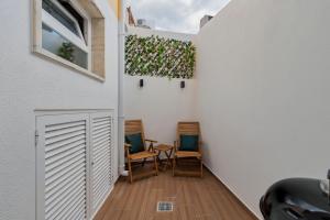 a hallway with two chairs and a window at Onofre Setúbal House in Setúbal
