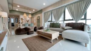 uma sala de estar com um sofá e uma mesa em Iskandar Residence by JBcity Home em Nusajaya