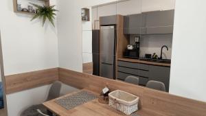 a kitchen with a table and a stainless steel refrigerator at Deea H24 in Râşnov
