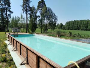 a swimming pool with a wooden fence around it at Kalliomajat in Ylivalli