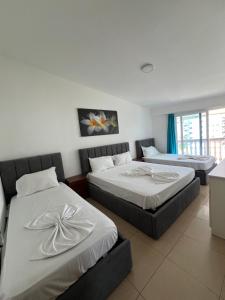 two beds in a hotel room with at Vila Deda Shengjin in Shëngjin +10 photos