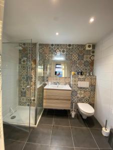 a bathroom with a shower and a sink and a toilet at Guesthouse The White House - gehele huisje in Klaaswaal +25 photos