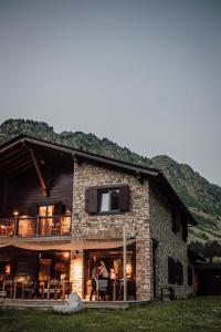 uma casa com pessoas sentadas na varanda em L´Ovella Negra Mountain Lodge em Canillo