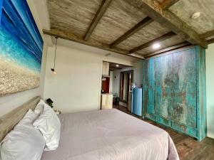 ein Schlafzimmer mit einem Bett und einem Wandgemälde in der Unterkunft Lavenderbnb Room 5 at Mataram City in Yogyakarta