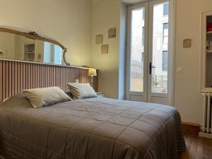 a bedroom with a large bed with a large window at Cœur de ville, Garage privé et gratuit avec Terrasse ! in Cahors