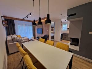 kuchnia i salon ze stołem i krzesłami w obiekcie Divčigora apartmani w mieście Divčibare