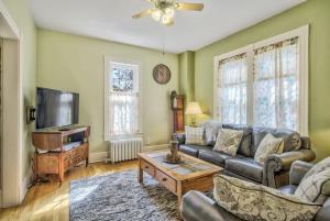 a living room with a couch and a tv at Victorian Charm With Hot Tub & Fire Pit Downtown in Colorado Springs