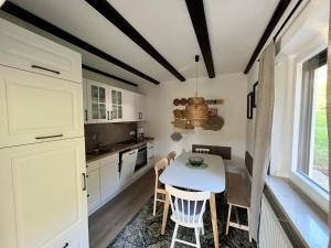 a kitchen with white cabinets and a table and chairs at FerienChata Bärenriegel in Arrach