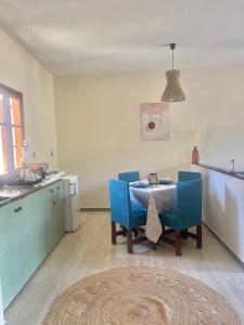a kitchen with a table and some blue chairs at LONG SUMMER in Sivota