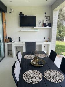 a dining room with a black table and chairs at Krum's Little Secret Villa in Vourvourou