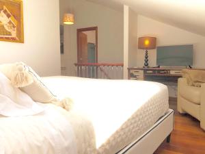 a bedroom with a white bed and a television at Dúplex Sierpes centro parking opcional in Salamanca +32 photos