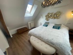 a bedroom with a large bed with a white comforter at Le Duplex Balnéo Maison climatisée in Saint-Martin-du-Tertre