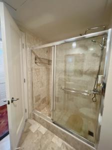 a shower with a glass door in a bathroom at Olympia Makati Studio former Somerset Olympia Makati in Manila