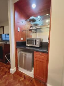 a kitchen with a microwave on a counter at Olympia Makati Studio former Somerset Olympia Makati in Manila