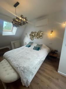 a bedroom with a large bed with a white comforter at Le Duplex Balnéo Maison climatisée in Saint-Martin-du-Tertre