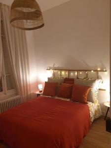 Un dormitorio con una cama roja con luces. en Demeure du Saule Madame, en Thieux