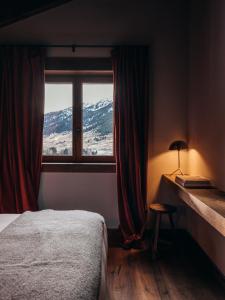a bedroom with a bed and a window with a view at L´Ovella Negra Mountain Lodge in Canillo