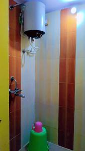 a bathroom with a green toilet and a water tank at Shree Hatkeshwar Home Stay Ujjain in Ujjain