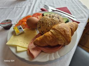 a plate of food with a sandwich and bread and cheese at B3 Hotel in Niederfell